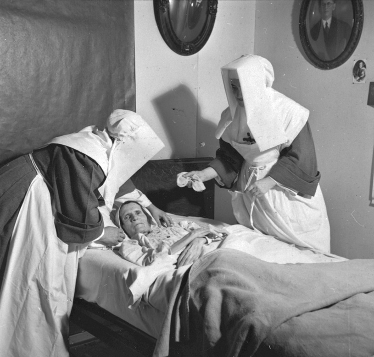 Reproduction d'une photographie de deux Filles de la Sagesse visitant des malades &agrave; domicile &agrave; Lavigne, Ontario, 1949.
