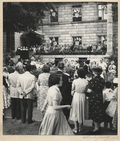 Reproduction d'une photographie du d&eacute;fil&eacute; de la Saint-Jean-Baptiste devant le presbyt&egrave;re de la paroisse Sainte-Anne d'Ottawa, 1956.