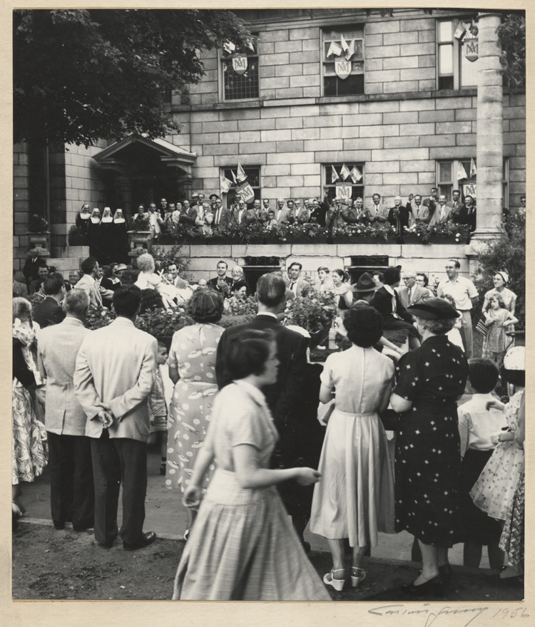 Reproduction d'une photographie du d&eacute;fil&eacute; de la Saint-Jean-Baptiste devant le presbyt&egrave;re de la paroisse Sainte-Anne d'Ottawa, 1956.