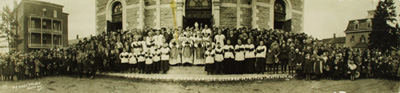 Reproduction d'une photographie de l'assembl&eacute;e sur le perron de l'&eacute;glise de Mattawa (Ontario), &agrave; l'occasion du 25e anniversaire de pr&ecirc;trise du r&eacute;v&eacute;rent Nelson J. Duquette, cur&eacute; de Mattawa, 20 octobre 1926.