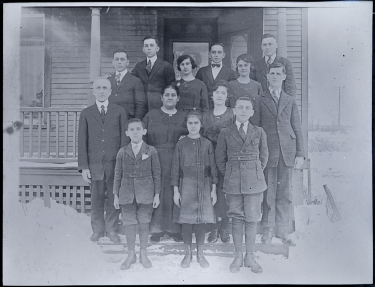 Reproduction d’une photographie de la famille de Napol&eacute;on Demers, dont tous les enfants travaillent &agrave; la Empire Cotton Mill, devant leur domicile, une maison appartenant &agrave; la compagnie, Welland (Ontario), ca 1920.