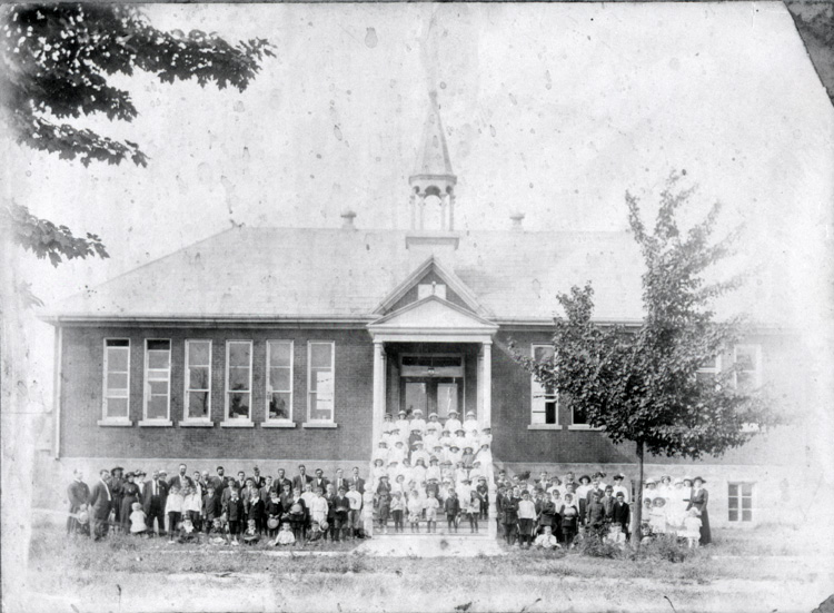 Reproduction d’une photographie des élèves devant l’école du village de Limoges (Ontario), 1914.